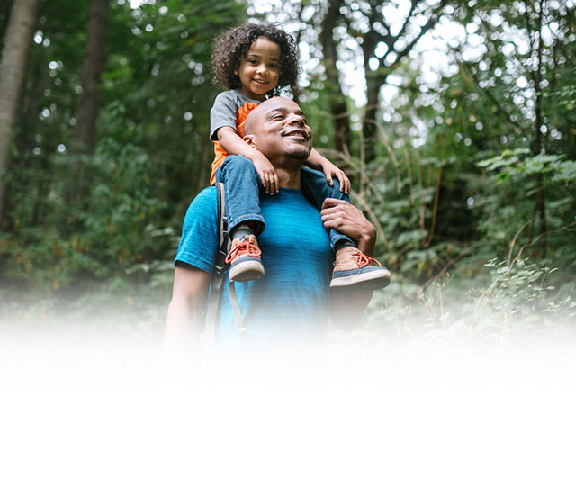 Father carrying son on top of his shoulder